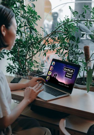 Image of person looking at laptop with EarthLab 2024 Impact Report